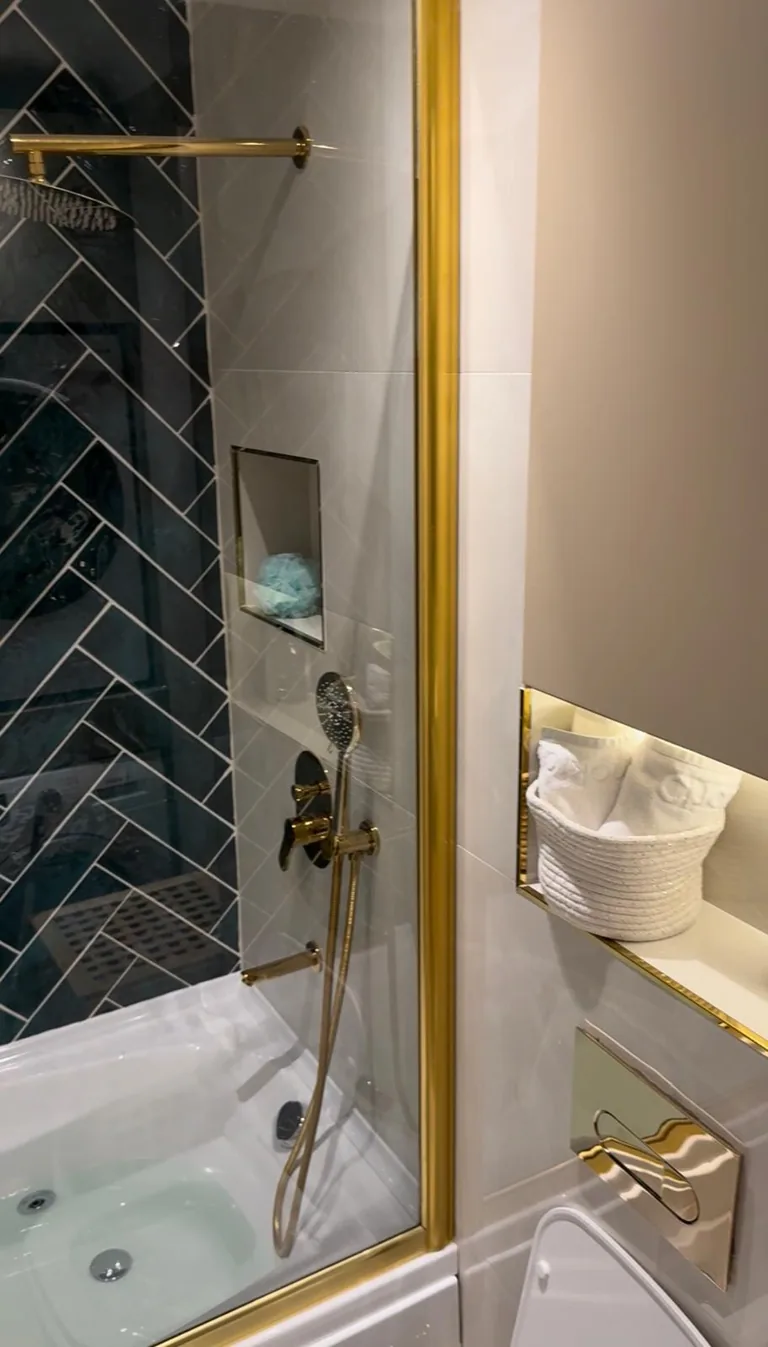 Yenilenen banyo — yeşil balıksırtı karo ve pirinç armatürler